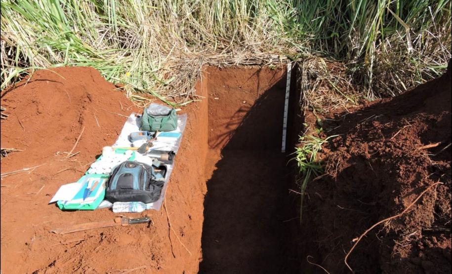 Perfil de Cambissolo Flúvico e materiais para descrição, coleta e classificação de solo.